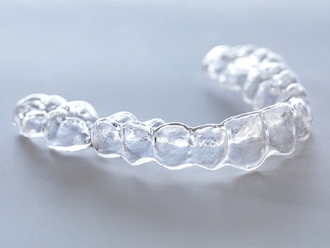 Clear aligner lying on gray surface