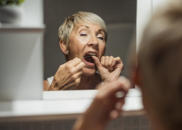 a woman flossing her dental implants