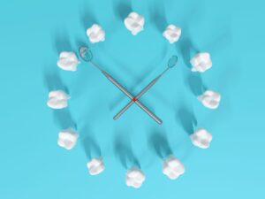 12 model teeth and 2 dental mirrors arranged like a clock on a pale blue surface