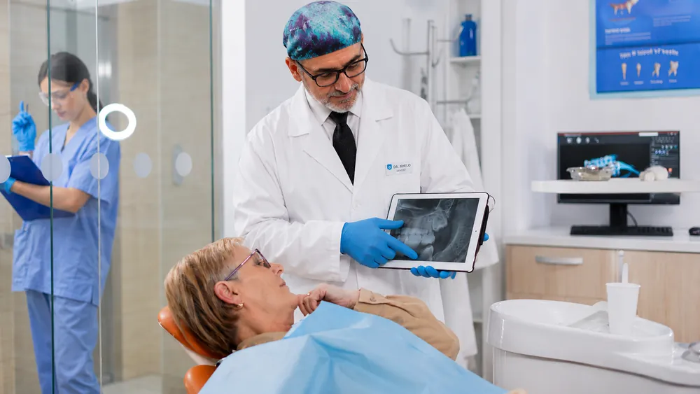 Dr. Xhelo Shuaipaj reviewing a digital X-ray with a patient