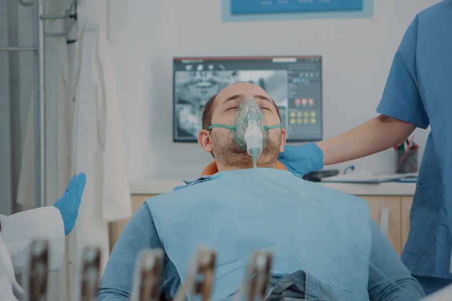 Patient wearing nitrous oxide mask during dental sedation procedure